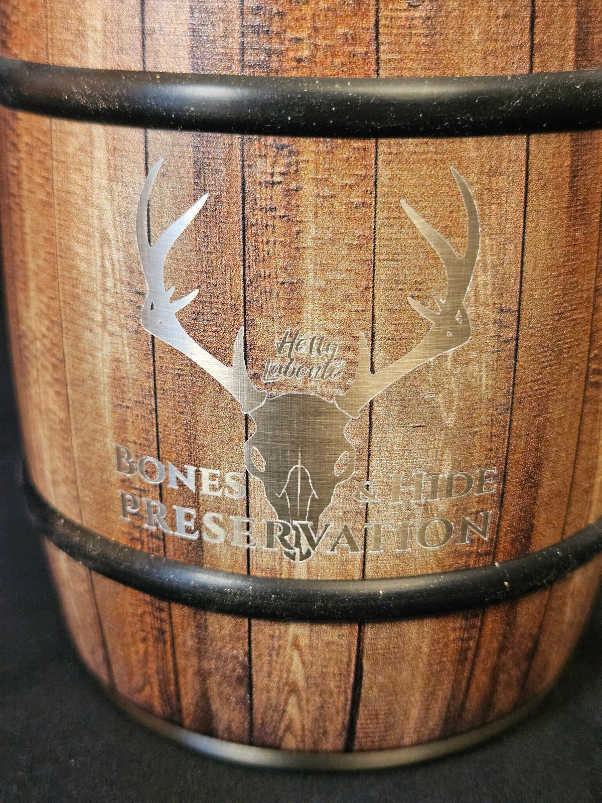 Close-up of engraved male antler skull logo on barrel mug