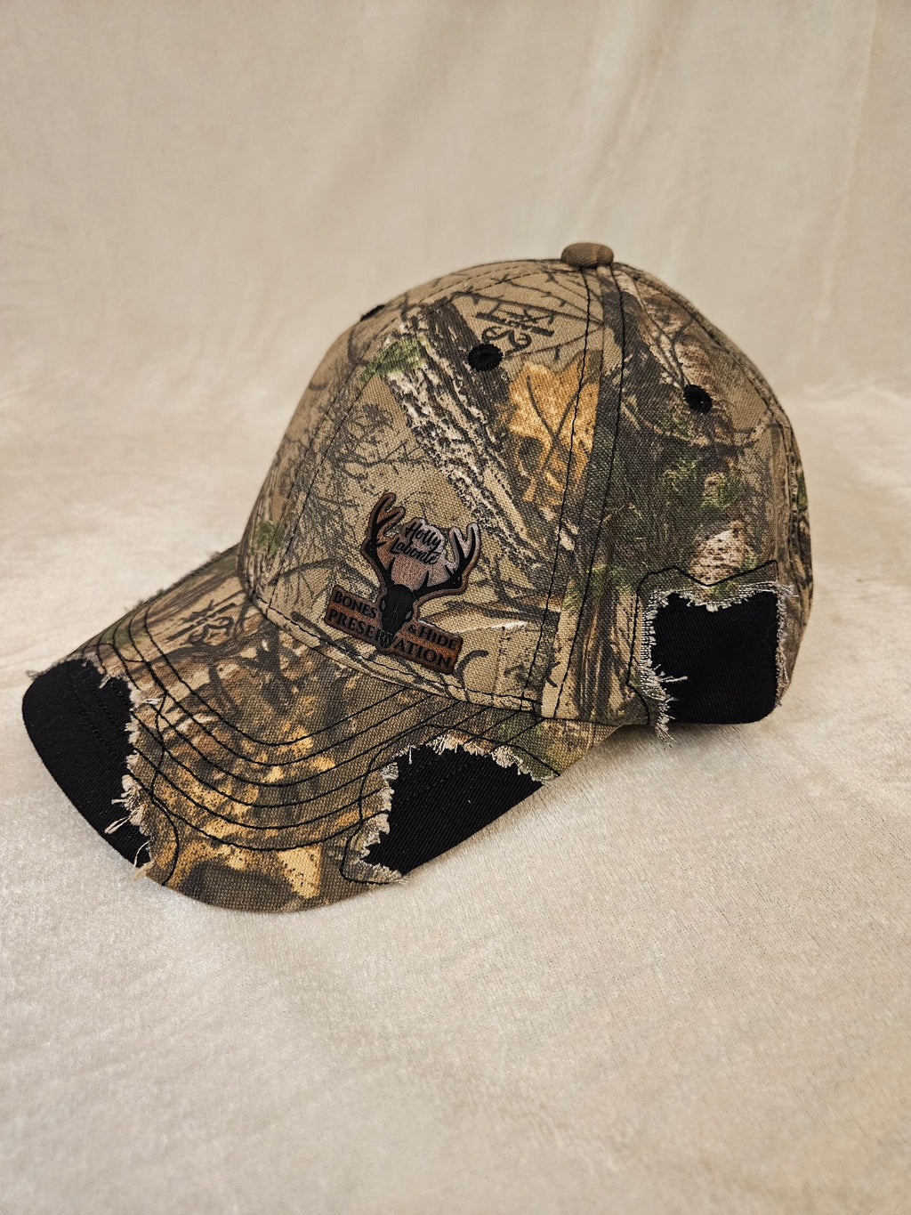 Camo hat with black distressed detailing, angled