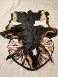 Kid goat rug with Christmas-print frill around the neck, black-edged backing, on cream linen