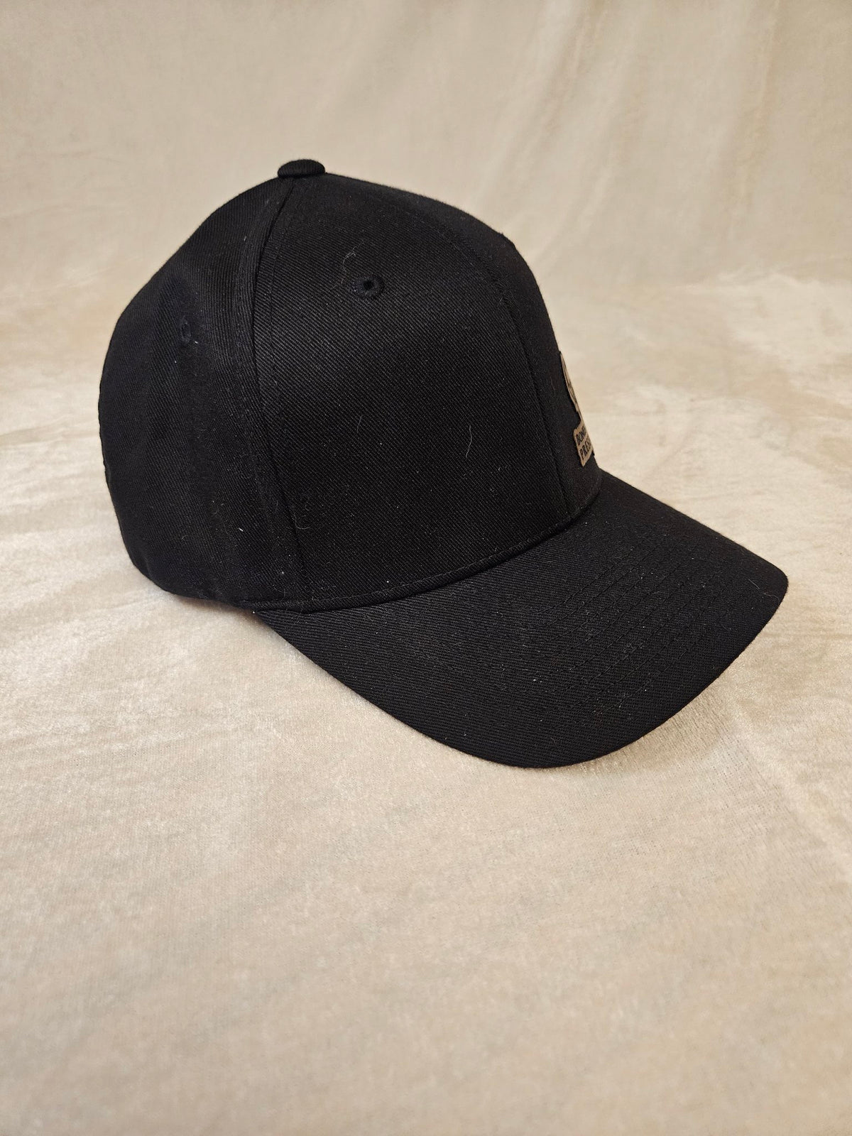 Black cap with engraved leather Bones & Hide Preservation patch, side