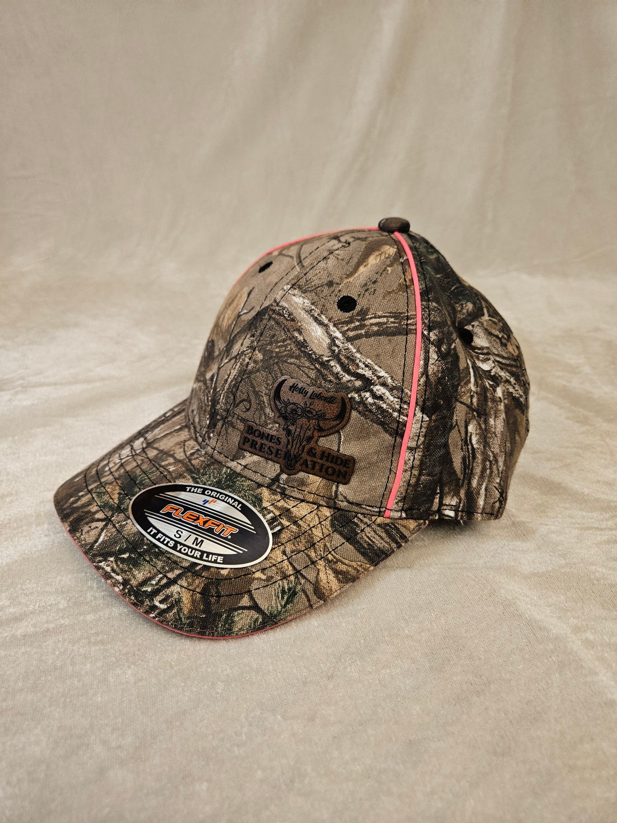 Women's camo Flexfit hat with engraved leather patch, other side