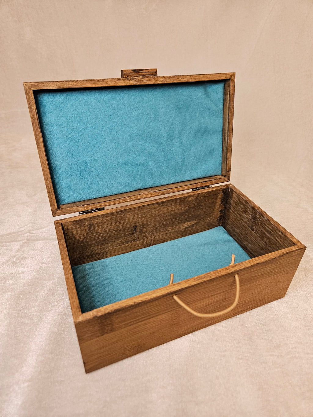 Handcrafted wooden skull box with teal velvet lining, open